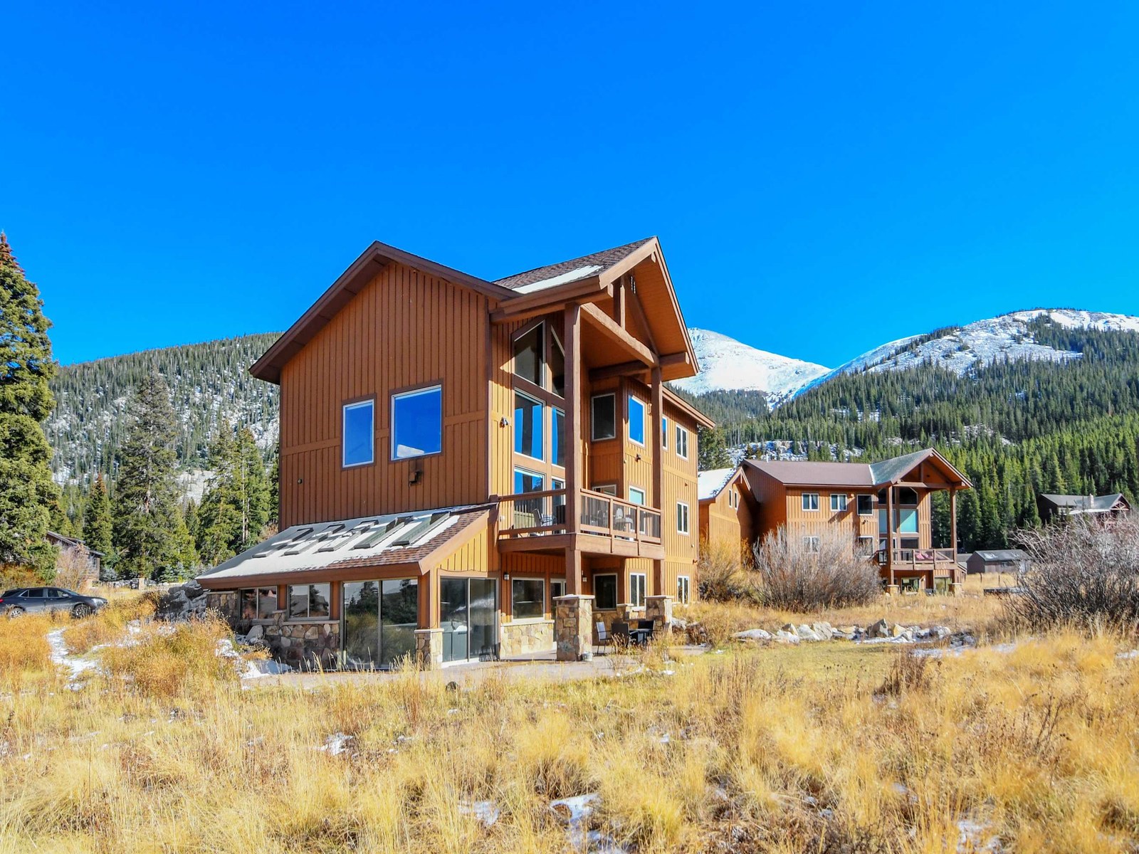 Orange Breckenridge mountain home below a snowy ridgeline